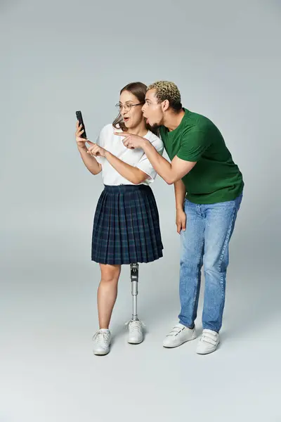 Dois amigos desfrutam de um momento lúdico enquanto olham para um smartphone juntos. — Fotografia de Stock