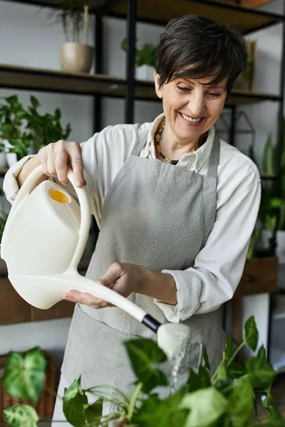 Happy gardener nurturing her plants with care in a beautiful studio. — Stock Photo