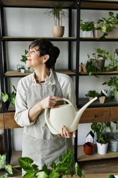 Садовник с любовью заботится о своих цветущих растениях в помещении. — стоковое фото