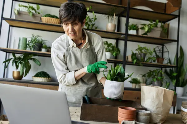 A gardener carefully nurturing her beloved plants in a cozy studio. — Stock Photo