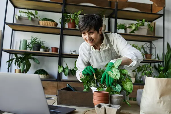 Una donna nutre le sue piante con amorevole cura nel suo sereno giardino interno. — Foto stock