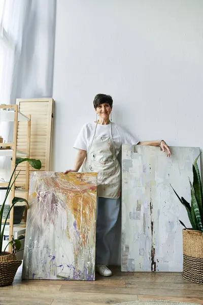 Une peintre joyeuse expose ses œuvres vibrantes dans l'espace créatif. — Photo de stock