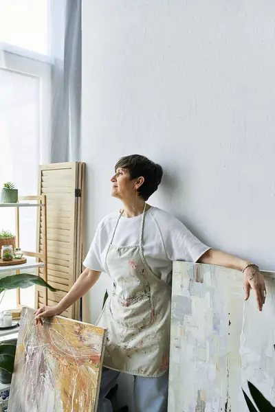 A painter enjoys a moment of inspiration in her vibrant art studio. — Stock Photo