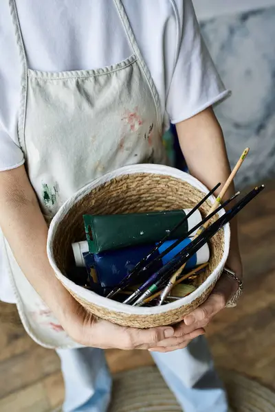 A woman enjoys her creative space while holding art materials. — Stock Photo
