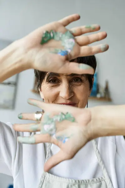 An artist reveals her paint splattered hands, celebrating her creative passion. — Stock Photo