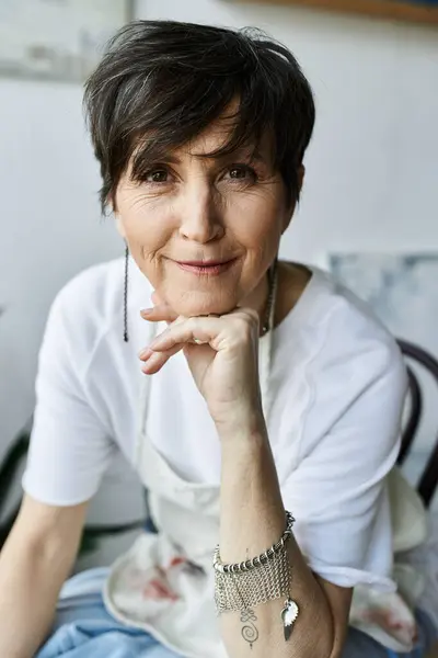 A mature woman enjoys her time in the art studio, expressing creativity. — Stock Photo