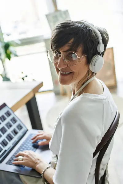 A skilled painter enjoys her artistic process while listening to music. — Stock Photo