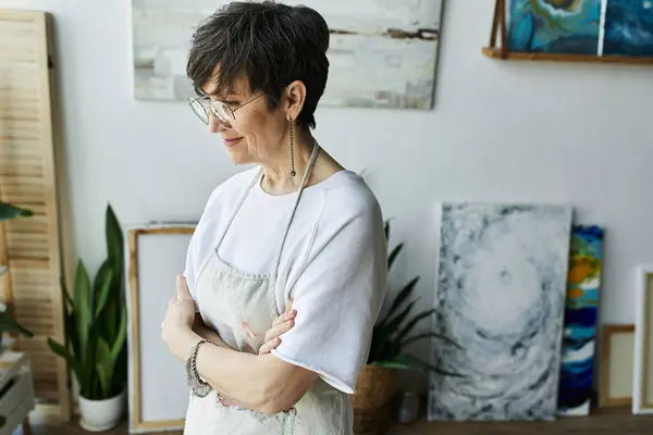 A contemplative artist enjoying her creative space and artwork. — Stock Photo