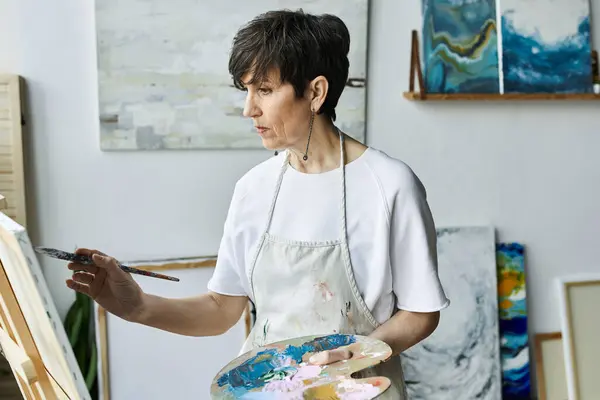 A passionate artist creates a vibrant masterpiece in her studio. — Stock Photo