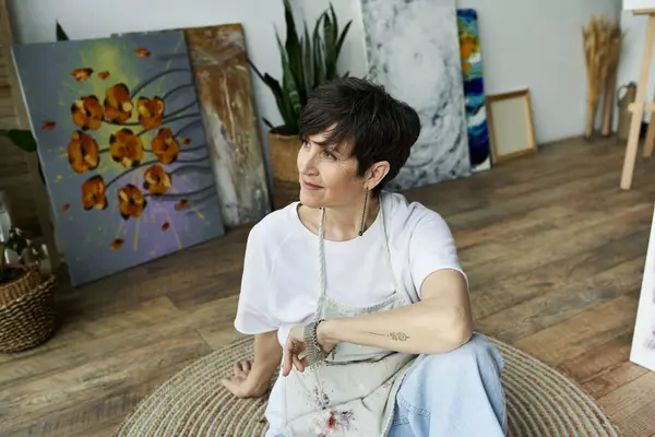 A painter calmly enjoying her creative space surrounded by artwork. — Stock Photo