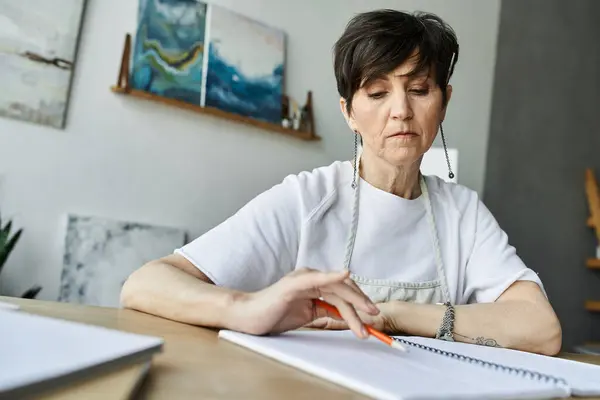 A dedicated painter thoughtfully sketching in her peaceful art studio. — Stock Photo