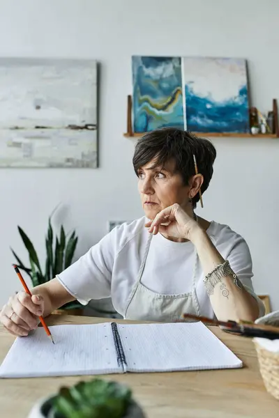 A contemplative artist creates in her vibrant studio space. — Stock Photo