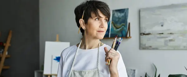 An artist contemplates her next creation in a colorful studio. — Stock Photo