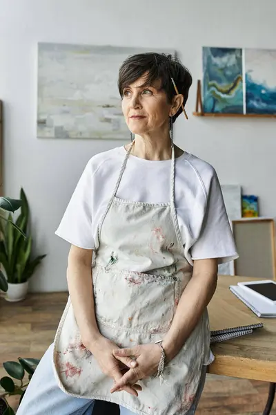 A thoughtful artist contemplates her next masterpiece in a bright studio. — Stock Photo