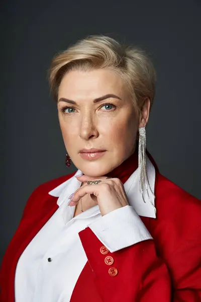 Una mujer aturde con un traje rojo chic, cautivando a la audiencia con su elegancia. - foto de stock