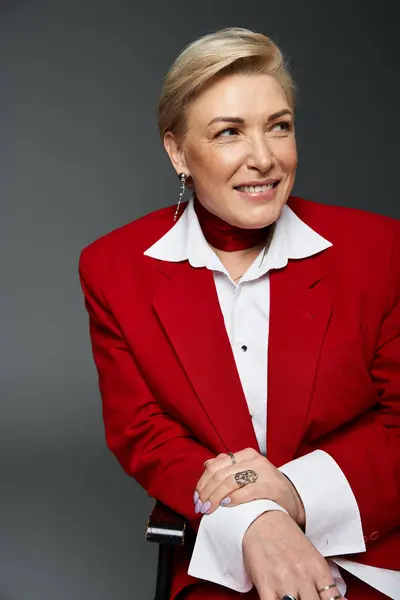 An adult woman dressed in red showcases elegance and poise, smiling warmly at the camera. — Stock Photo