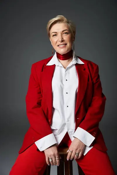 An elegant woman wearing a stylish red suit and white shirt exudes confidence and grace. — Stock Photo