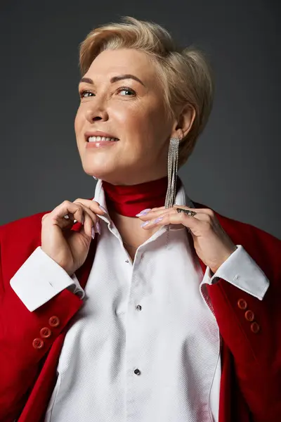 An adult woman showcases her elegance with a stylish outfit and confident smile in a dark setting. — Stock Photo