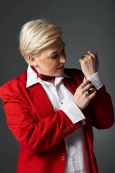 A fashionable woman elegantly adjusts her sleeve while exuding poise and sophistication. — Stock Photo