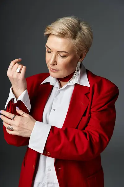 A stylish woman adjusts her jacket, highlighting her chic look in an elegant setting. — Stock Photo