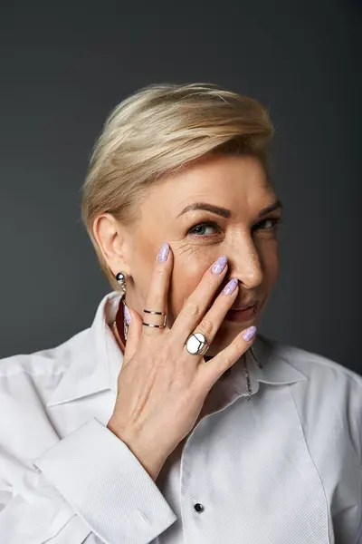 Доросла жінка демонструє свій елегантний стиль, граціозно позуючи з грайливим виразом. — стокове фото