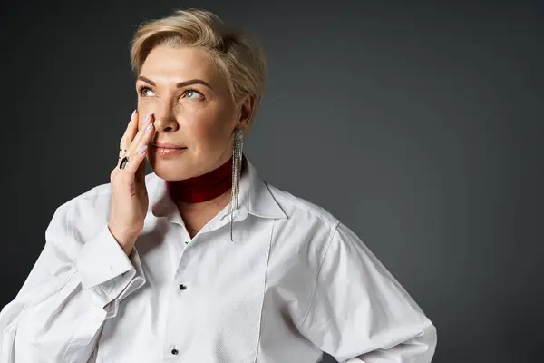 An adult woman dressed in elegant attire contemplates thoughtfully, showcasing sophisticated style. — Stock Photo