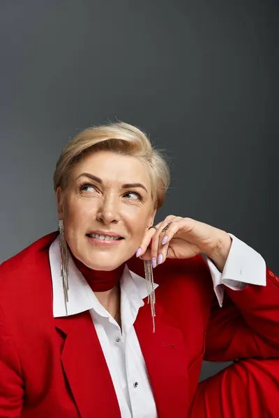 A confident woman in red attire strikes a thoughtful pose, showcasing her elegant style. — Stock Photo