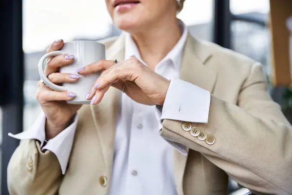 Eine stilvolle Frau schlürft Kaffee, zeigt ihre schicken Nägel und entspannte Stimmung. — Stockfoto