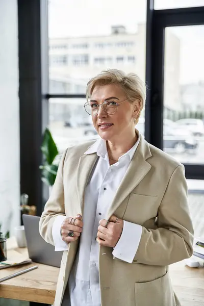 An adult woman in fashionable attire confidently poses in a chic, stylish workspace. — Stock Photo