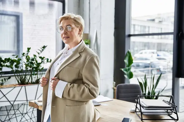 An elegant woman stands confidently in a contemporary office, exuding sophistication and style. — Stock Photo