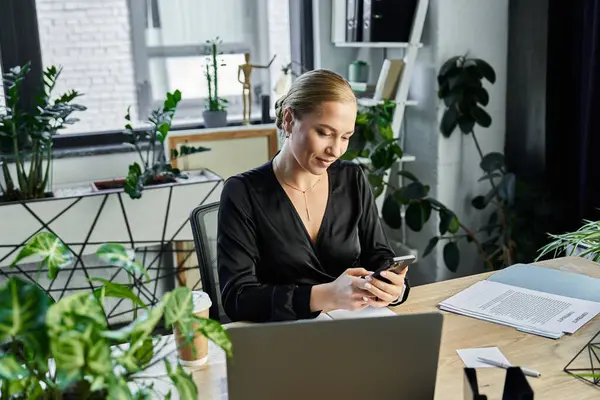 A young, beautiful plus size woman is focused on her phone while working in a stylish office. — Stock Photo