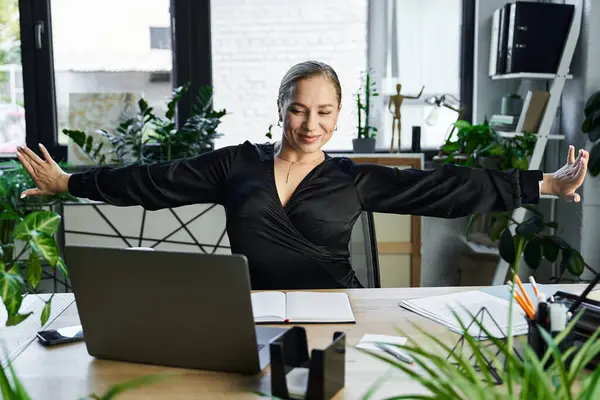 A joyful plus size woman embraces her workspace while engaging in creative tasks. — Stock Photo