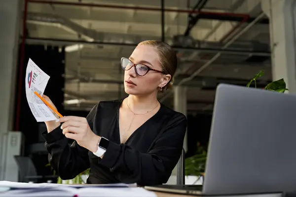 A young plus size woman attentively examines documents while working at her desk. — Stock Photo