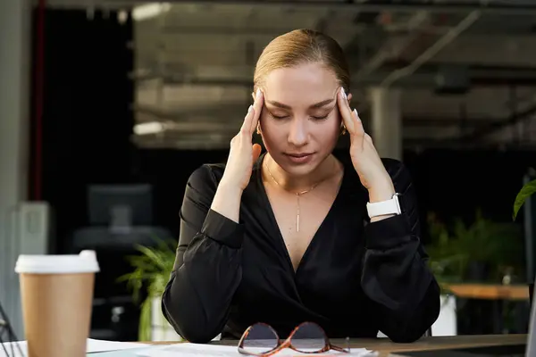 A young, beautiful plus size woman works diligently at her desk, deep in thought. — Stock Photo