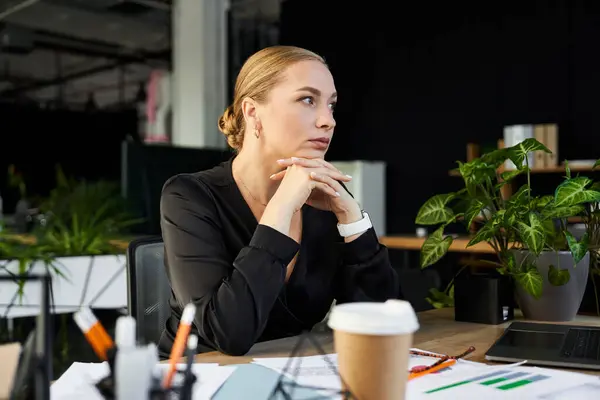 A young beautiful plus size woman focuses intently while working at her office desk. — Stock Photo