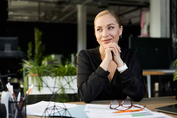 A young plus size woman in a stylish black outfit contemplates her work amidst vibrant greenery. — Stock Photo