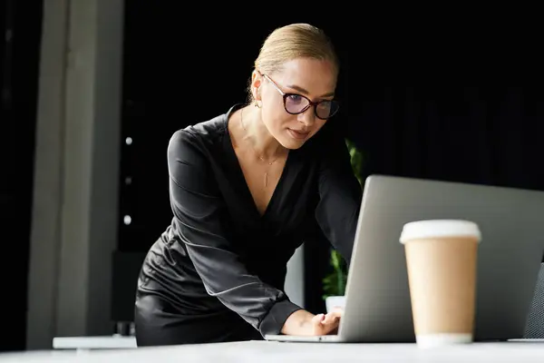 A dedicated young plus size woman is working intently at her laptop in a stylish office environment. — Stock Photo
