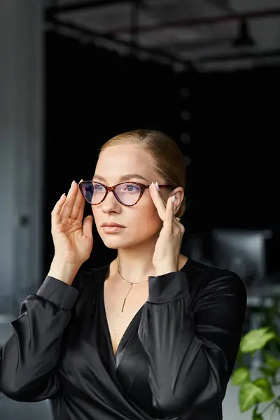 A young plus size woman adjusts her glasses while concentrating on her work tasks. — Stock Photo
