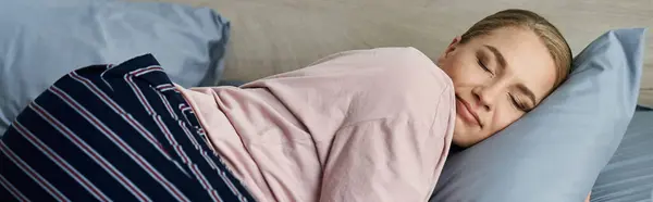 Une jeune femme de taille plus profite d'un moment de repos, couchée confortablement sur le côté au lit. — Photo de stock