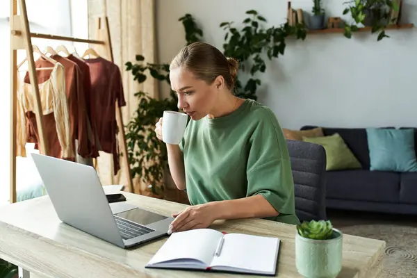 A beautiful plus size woman relaxes at home, working on her laptop while sipping coffee. — Stock Photo