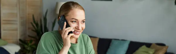 A joyful plus size woman engaged in a cheerful phone conversation while relaxing indoors. — Stock Photo