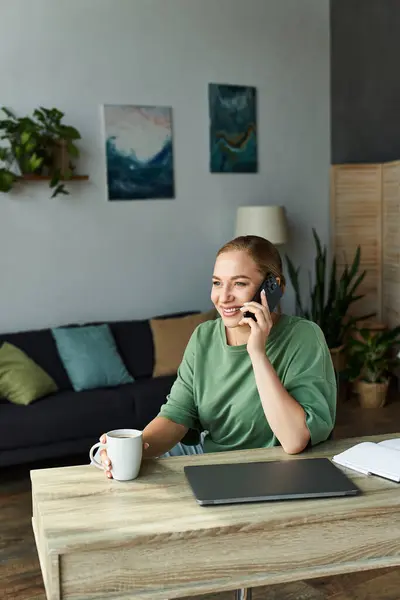 Um jovem alegre plus tamanho mulher bate-papos no telefone enquanto sorvendo café em sua sala de estar. — Fotografia de Stock