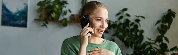 Una joven mujer de talla grande charla felizmente en su teléfono, rodeada de plantas y un ambiente relajado. — Stock Photo