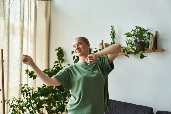 Una giovane donna allegra balla a casa, abbracciando il suo spirito gioioso e l'ambiente vibrante. — Foto stock