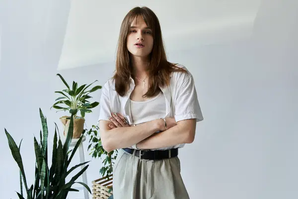A young man with long hair showcases his unique fashion sense in a stylish indoor setting. — Stock Photo