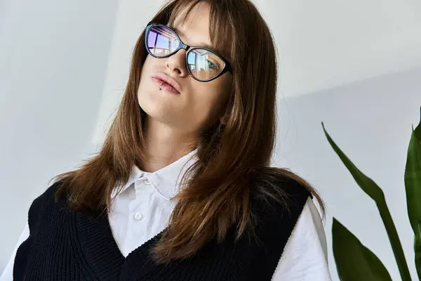 A trendy young person showcases a unique fashion sense while posing confidently in a bright room. — Stock Photo