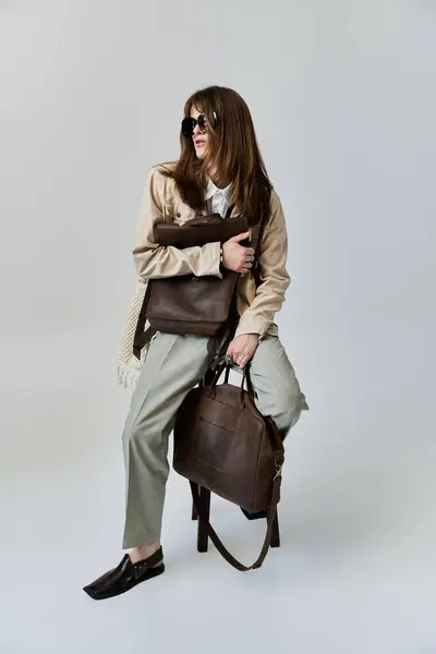 Un jeune homme branché met en valeur son style avec des sacs, respirant la confiance dans un cadre moderne. — Photo de stock