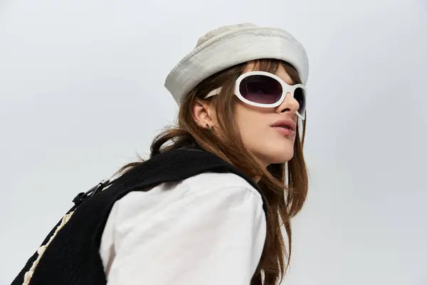 A fashionable young man poses confidently, highlighting his trendy outfit and distinctive shades. — Stock Photo