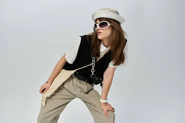 A fashionable young man poses confidently in trendy attire against a minimalist backdrop. — Stock Photo