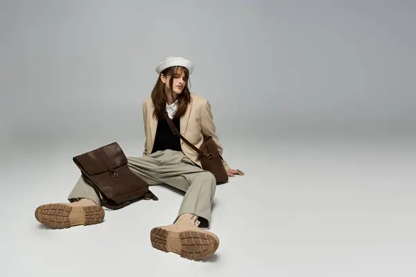 A young man expresses his fashion sense, sitting casually while wearing trendy clothing. — Stock Photo